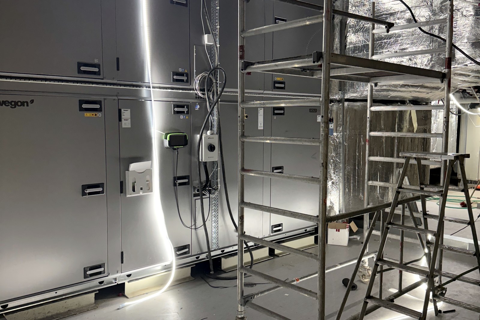 Montör installerar ventilationskanaler från saxlift i kommersiell fastighet — KDM Ventilation